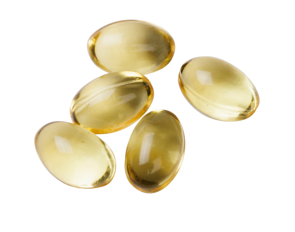 Five yellow capsules on a white background