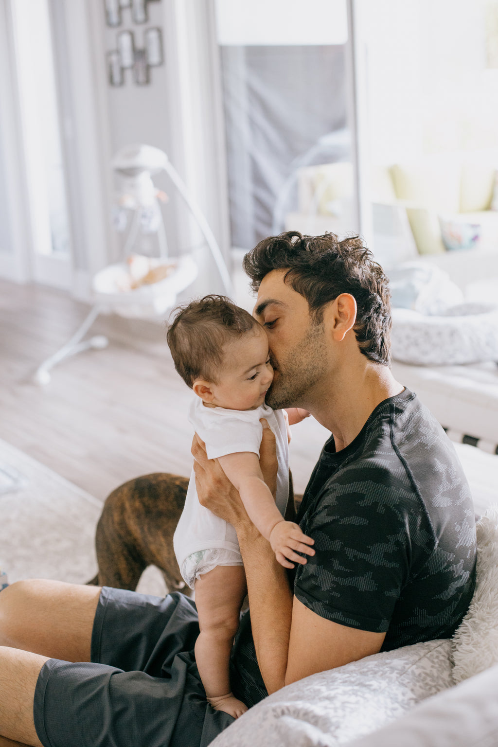 person-holds-a-baby-close-and-kisses-their-cheek