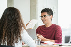 young-man-in-meeting-going-over-reports